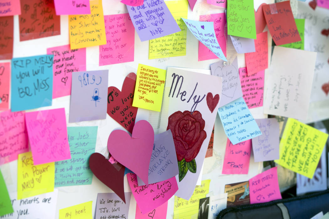 Notes for Trader Joe's employees, including Melyda Corado are posted by a makeshift memorial of flowers, candles and notes on the sidewalk outside the Silver Lake Trader Joe's store in Los Angeles ...