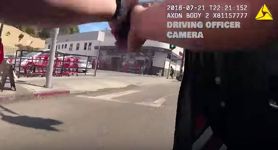In this Saturday, July 21, 2018 frame from body camera video released by the Los Angeles Police Department, an officer fires at suspect Gene Evin Atkins running into a Trader Joe's market after cr ...