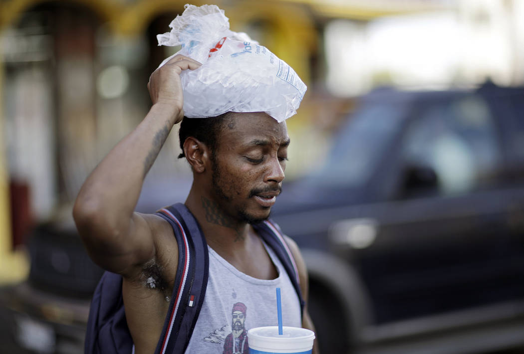 Ricki McElwee walks with a bag of his ice on his head to cool off Wednesday, July 25, 2018, in Las Vegas. The National Weather Service has issued an excessive heat warning for the Las Vegas valley ...