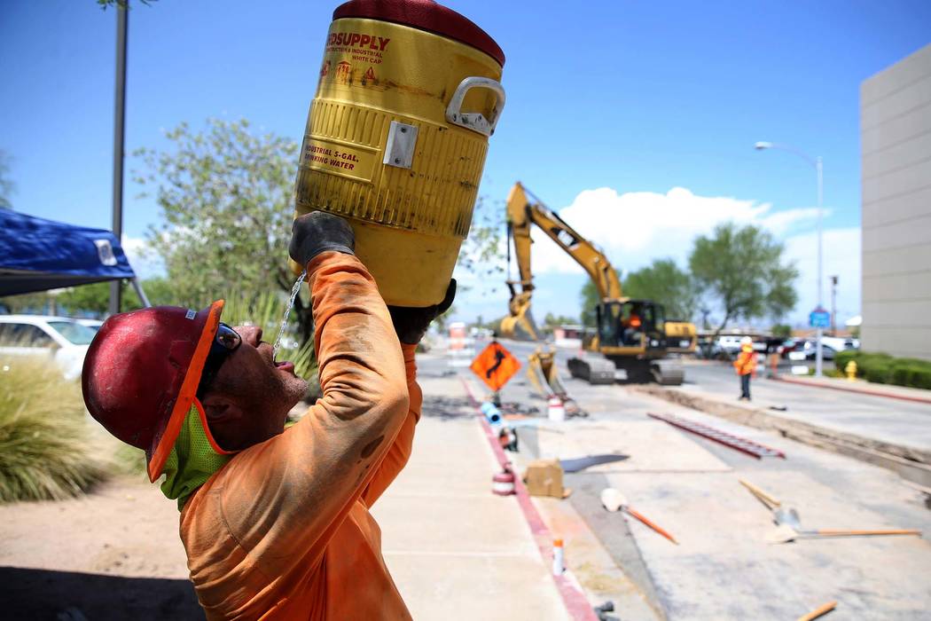 Todd Hassey takes a water break while laying pipe under Basic Road at Lynn Street near Henderson City Hall Tuesday, July 24, 2018. (K.M. Cannon/Las Vegas Review-Journal) @KMCannonPhoto