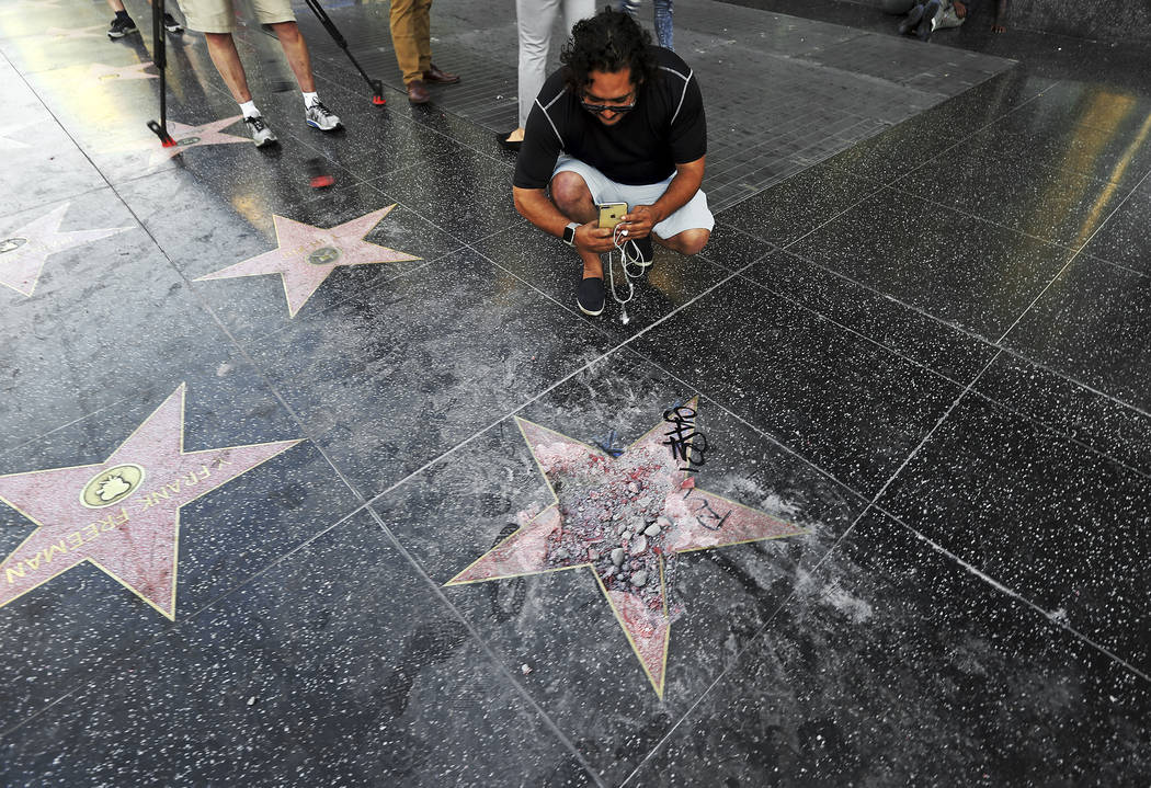 Victor Lomelli of Los Angeles blogs over the vandalized star of Donald Trump on the Hollywood Walk of Fame Wednesday morning, July 25, 2018, in Los Angeles. Authorities say the vandalism was repor ...