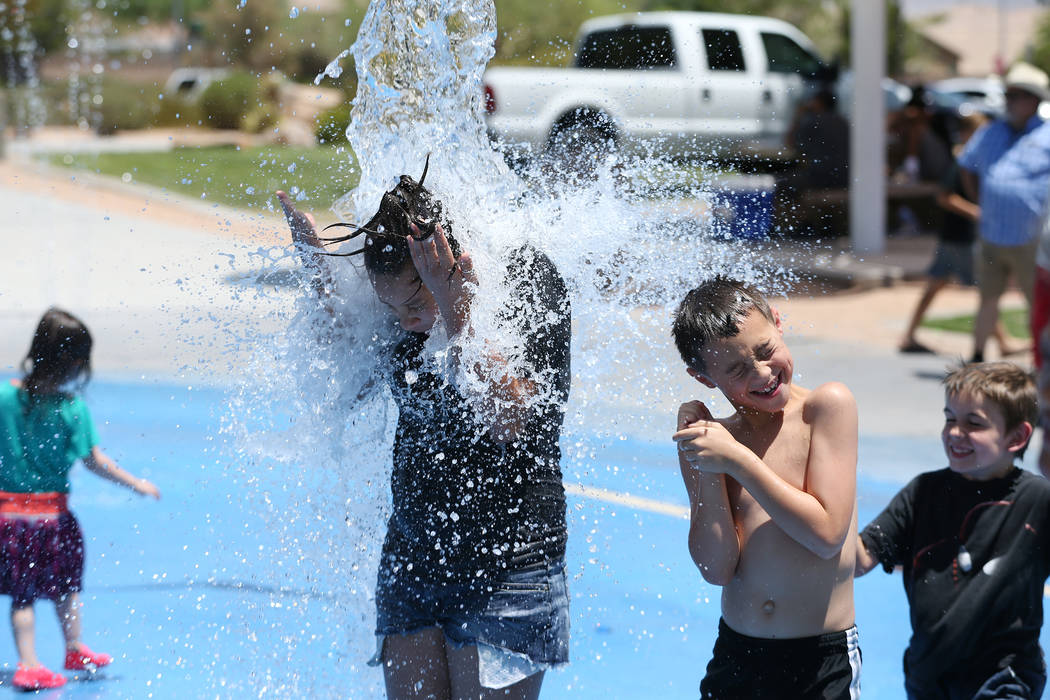 Calicia Marquez, left, 12, and Colby Drohn, 7, play on the splash pad at Gilcrease Brothers Park in Las Vegas, Saturday, June 23, 2018. Erik Verduzco Las Vegas Review-Journal @Erik_Verduzco