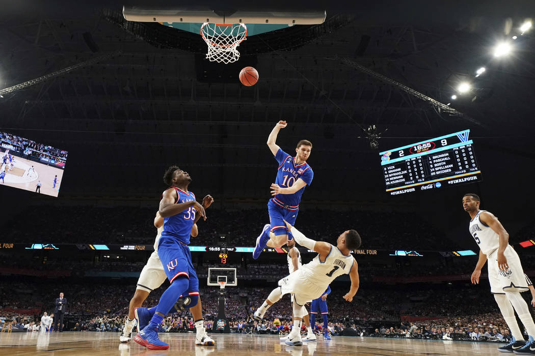 Villanova guard Jalen Brunson (1) is fouled by Kansas guard Sviatoslav Mykhailiuk (10) during the first half in the semifinals of the Final Four NCAA college basketball tournament, Saturday, March ...