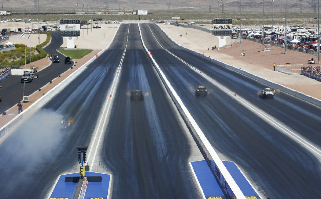 Funny Cars take off from the starting line during the first round of final eliminations on the final day of the DENSO Spark Plug NHRA Four-Wide Nationals at The Strip at Las Vegas Motor Speedway i ...