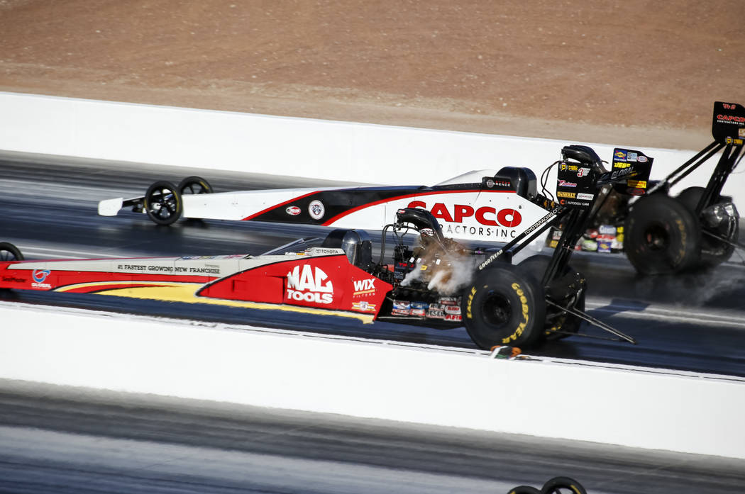 Top Fuel drivers Steve Torrence, top, and Doug Kalitta compete in the final elimination race of the DENSO Spark Plug NHRA Four-Wide Nationals at The Strip at Las Vegas Motor Speedway in Las Vegas ...