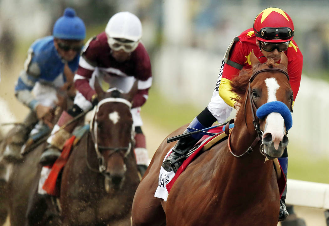 In this June 9, 2018, file photo, Justify (1), with jockey Mike Smith up, leads the field as it approaches the first turn during the 150th running of the Belmont Stakes horse race in Elmont, N.Y. ...