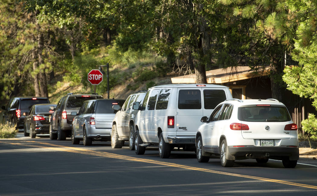 Vehicles leave Yosemite National Park, Calif., on Tuesday, July 24, 2018, as the Ferguson Fire burns nearby. Parts of the park, including Yosemite Valley, will close Wednesday as firefighters work ...