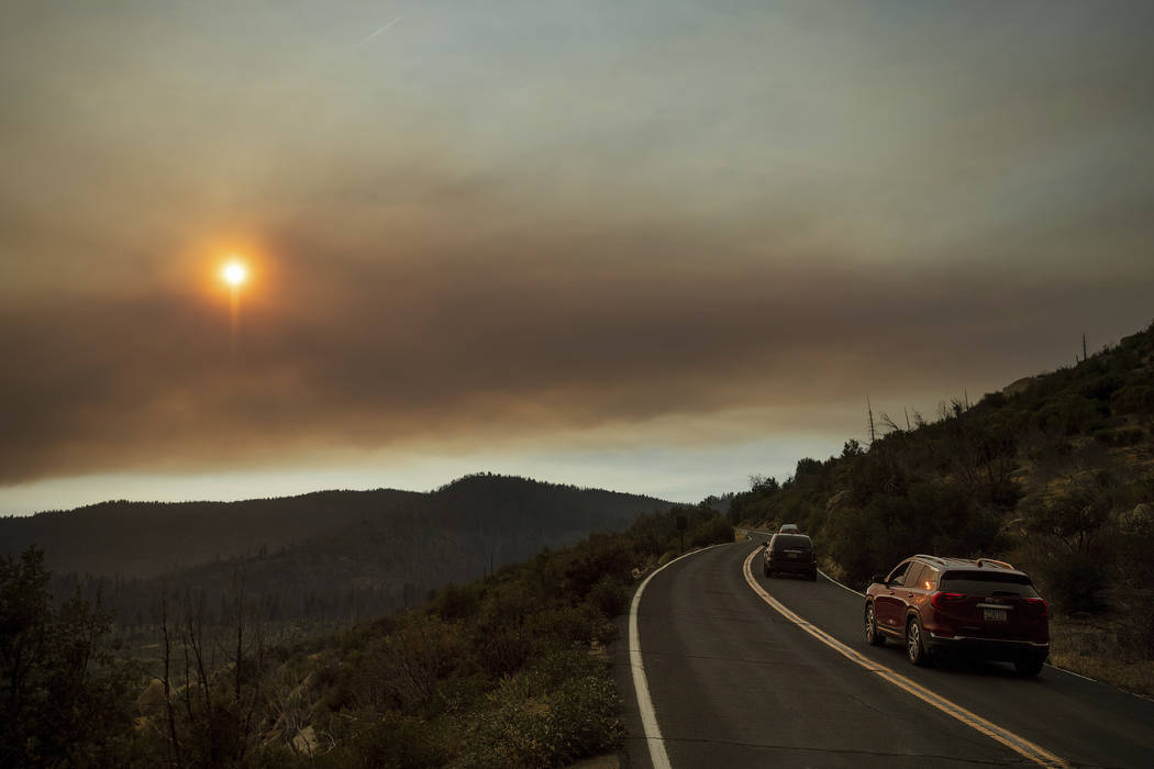 As smoke from the Ferguson Fire fills the sky, vehicles leave Yosemite Valley in Yosemite National Park, Calif., on Tuesday, July 24, 2018. Parts of the park, including Yosemite Valley, will close ...