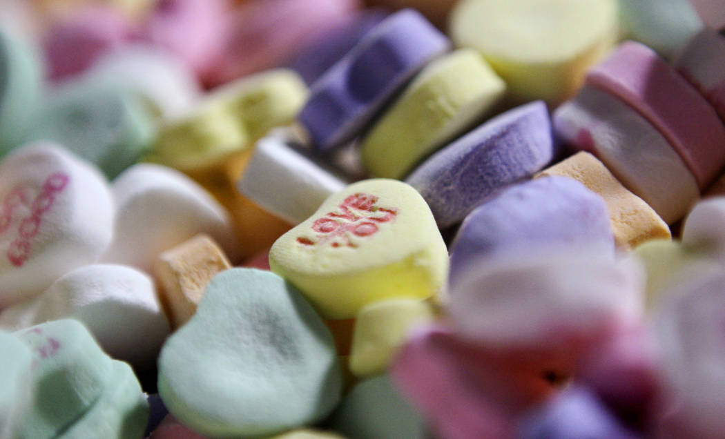 FILE - In this Jan. 14, 2009, file photo, colored "Sweethearts" candy is held in bulk prior to packaging at the New England Confectionery Company in Revere, Mass. The owner of a company ...