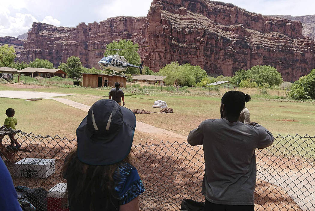 This Thursday, July 12, 2018 photo released by Benji Xie shows a helicopter landing to rescue people from flooding on the Havasupai reservation in Supai, Ariz. Rescue workers were evacuating about ...
