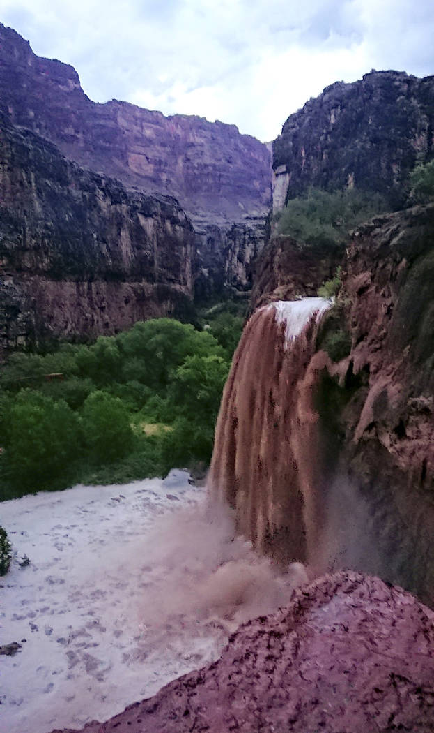 This Wednesday, July 11, 2018 photo released by Benji Xie shows flooding from a waterfall on the Havasupai reservation in Supai, Ariz. About 200 tourists were being evacuated Thursday from a campg ...