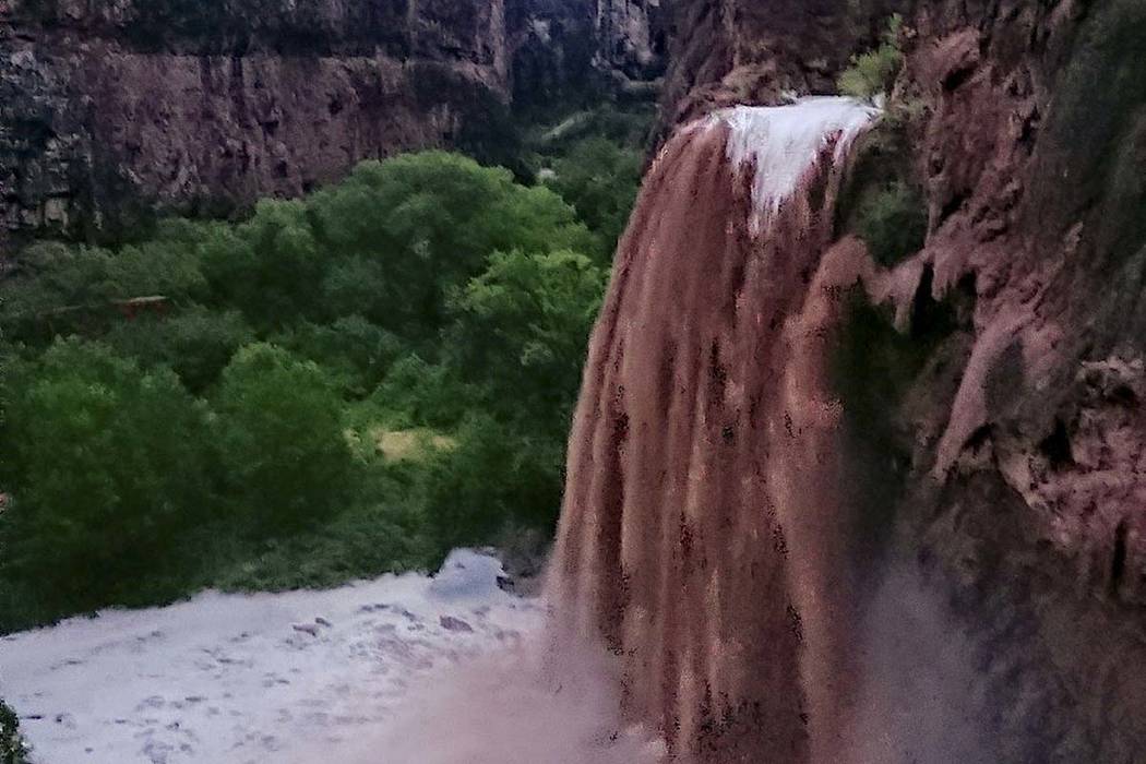 This Wednesday, July 11, 2018 photo released by Benji Xie shows flooding from a waterfall on the Havasupai reservation in Supai, Ariz. About 200 tourists were being evacuated Thursday from a campg ...