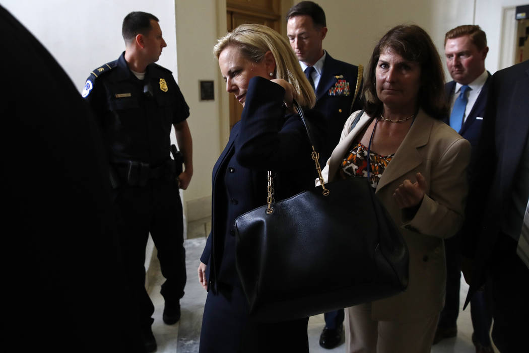 Homeland Security Secretary Kirstjen Nielsen, center, adjusts her handbag as she leaves a closed doors meeting with the Congressional Hispanic Caucus, Wednesday, July 25, 2018, on Capitol Hill in ...