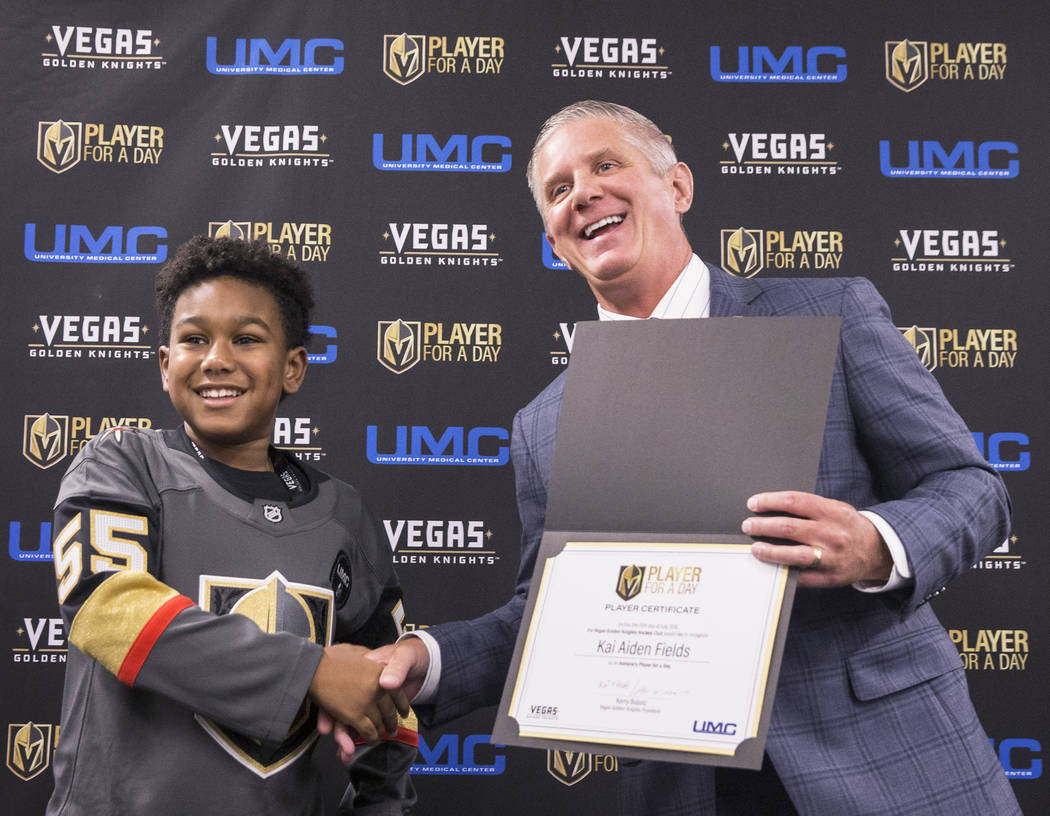 Kai Aiden Fields, left, shakes hands with Golden Knights President Kerry Bubolz after signing his contract during UMC's Player for a Day event where pediatric patients get to experience a day in t ...