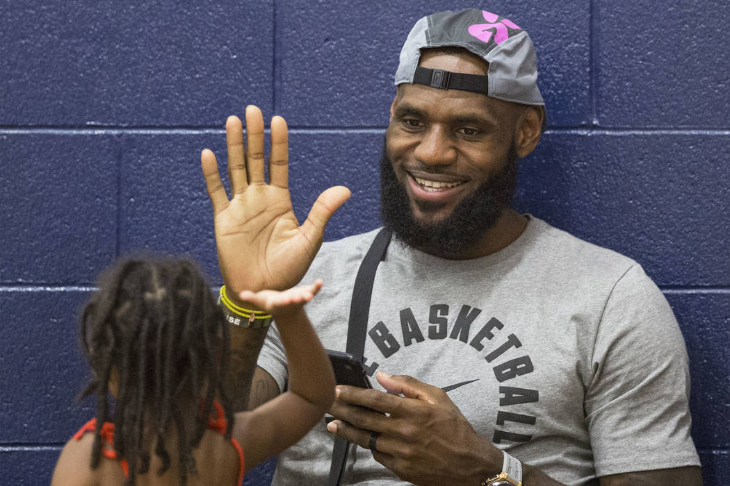 Los Angeles Lakers power forward LeBron James high fives his daughter Zhuri before the start of his son LeBron James Jr.'s Made Hoops Summer Showcase game on Wednesday, July 25, 2018, at Liberty H ...