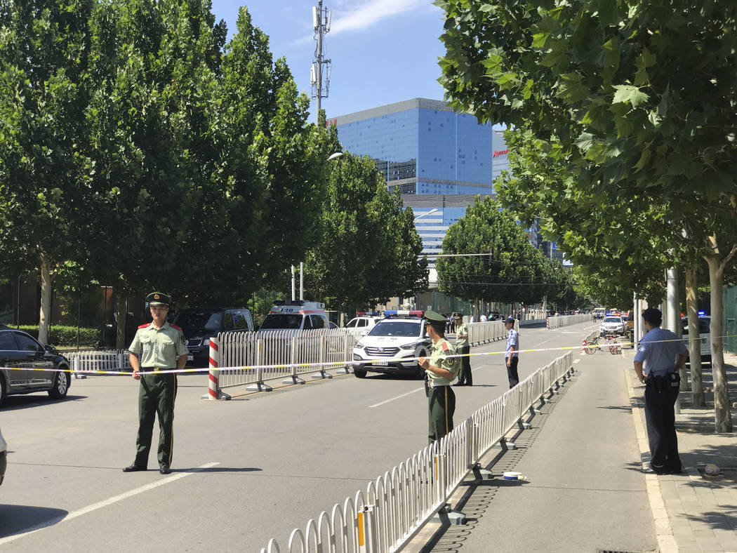 Paramilitary policemen seal off the road leading to the U.S. Embassy in Beijing Thursday, July 26, 2018. (AP Photo/Andy Wong)