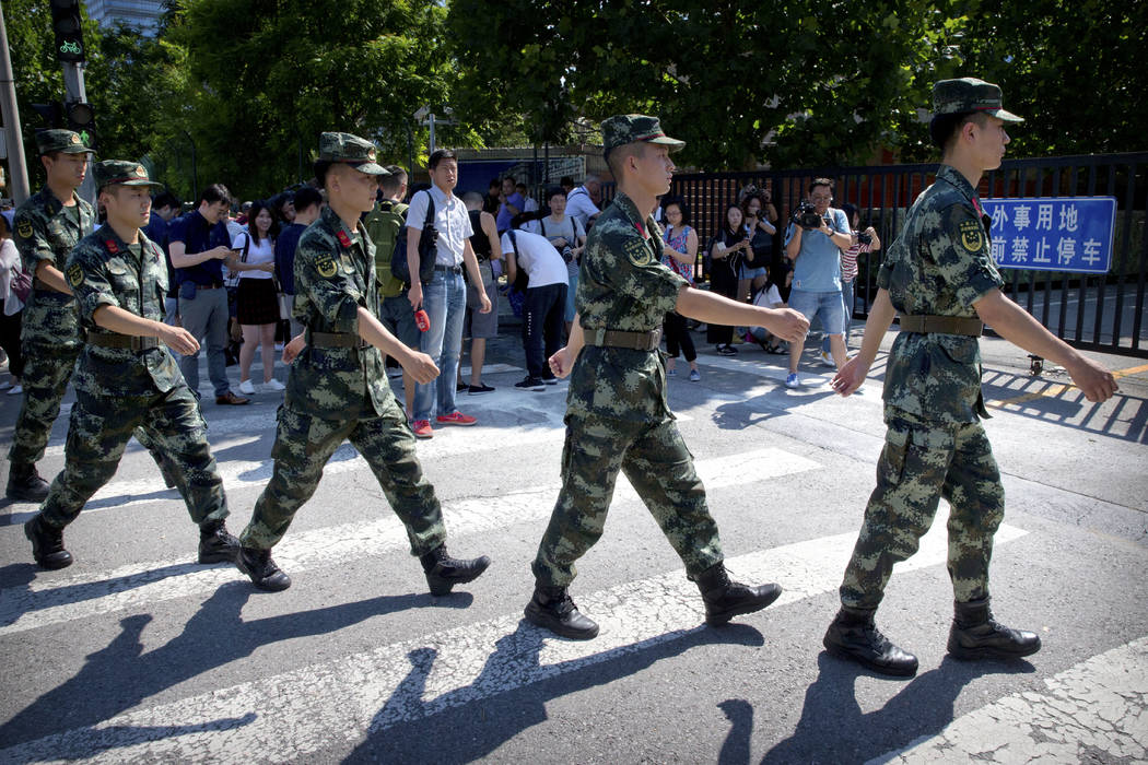 Chinese paramilitary police march in formation past the site of an incident near the U.S. Embassy in Beijing, Thursday, July 26, 2018. (AP Photo/Mark Schiefelbein)
