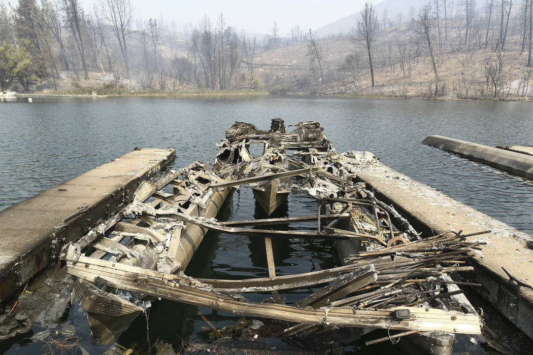 The remains of a boat burned by a wildfire is seen on a lake Thursday, July, 26, 2018, in Whiskeytown, Calif. (Hung T. Vu/The Record Searchlight via AP)