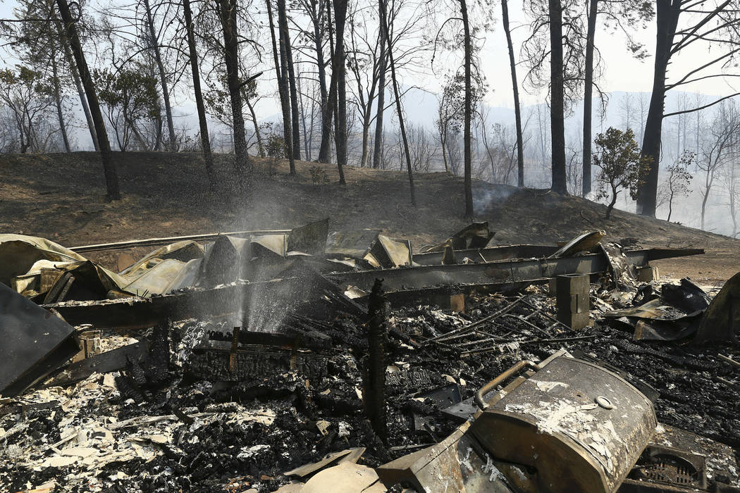 The remains of a home burned by a wildfire is seen Thursday, July, 26, 2018, in Whiskeytown, Calif. C(Hung T. Vu/Record Searchlight via AP)