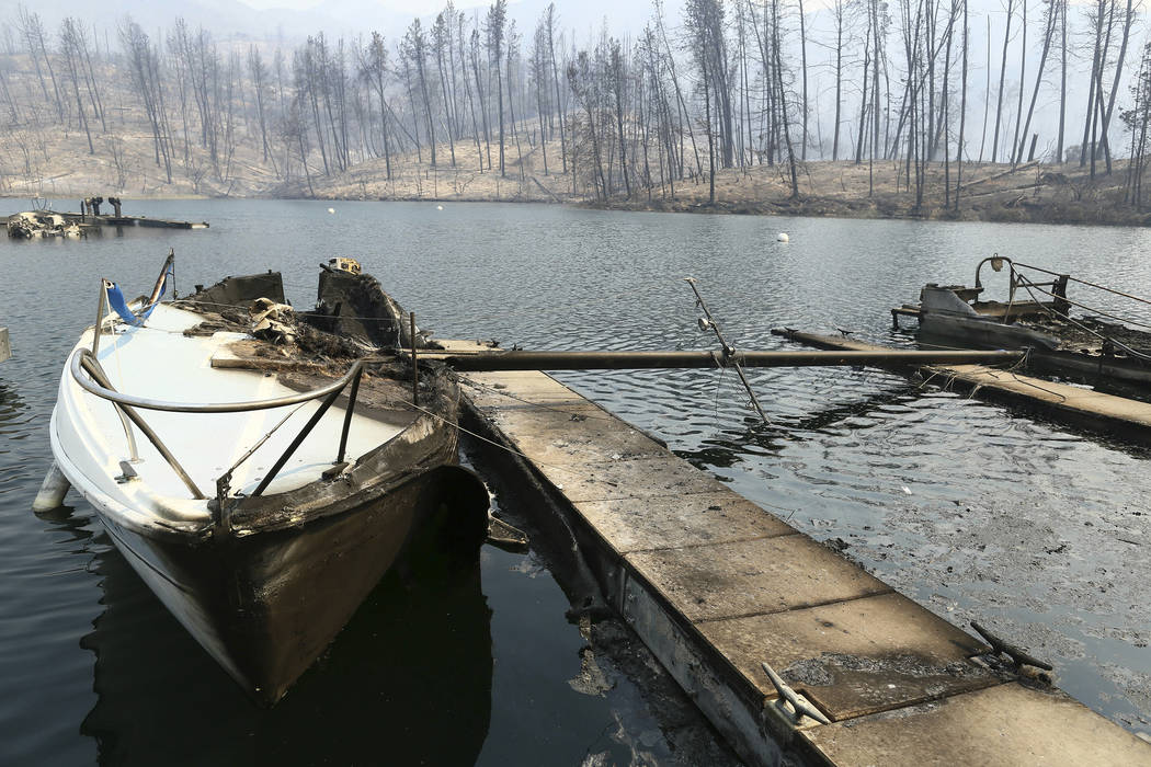 A sailboat burned by a wildfire is seen on a lake Thursday, July, 26, 2018, in Whiskeytown, Calif. (Hung T. Vu/The Record Searchlight via AP)