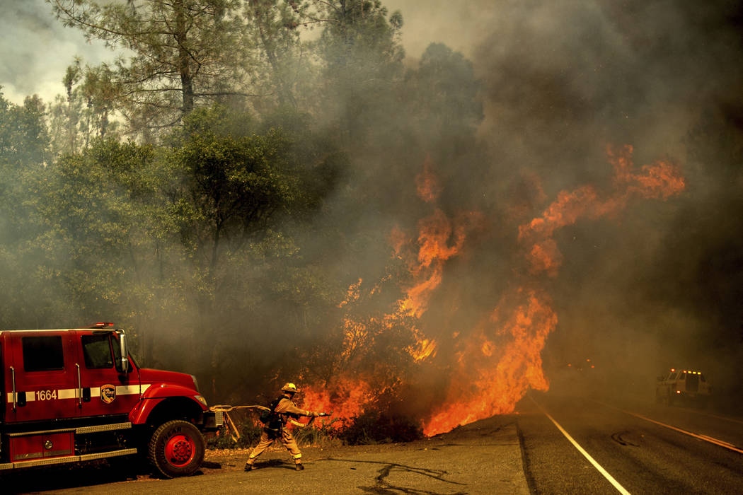 A firefighter battles the Carr Fire as it burns near Shasta, Calif., on Thursday, July 26, 2018. (AP Photo/Noah Berger)