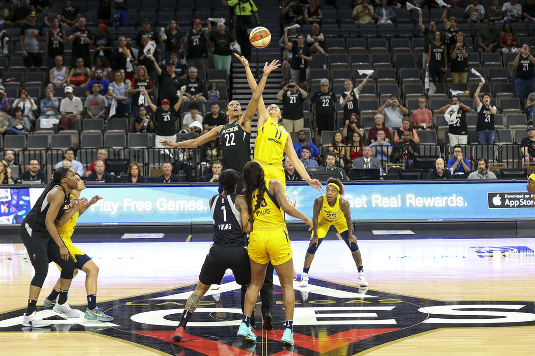 Las Vegas Aces center A'ja Wilson (22) and Indiana Fever forward Natalie Achonwa (11) tip off to start the first half of a WNBA basketball game at the Mandalay Bay Events Center in Las Vegas on Su ...