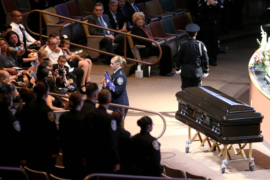 Michele Freeman, chief of Las Vegas Department of Public Safety, gives the American flag to widow Arlyn Eng during funeral services for Las Vegas Corrections Officer Kyle Eng at Canyon Ridge Chris ...