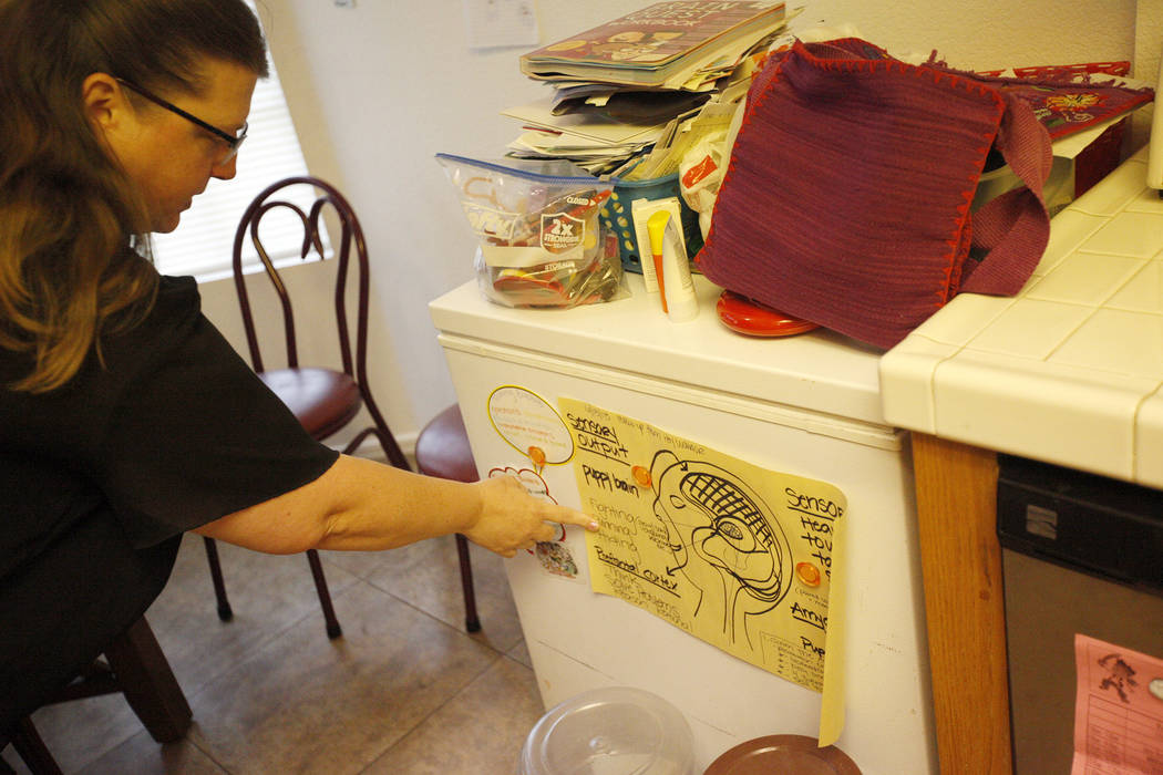 Carrie Olsen points out a chart that helps her son Daemion Olsen, 9, understand his mental health better at her home in Las Vegas, Tuesday, July 31, 2018. Medicaid announced a new rule in June tha ...