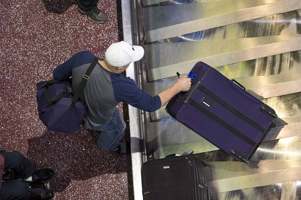 A man traveling on Allegiant grabs his belongings from baggage claim at Terminal 1 at McCarran International Airport in Las Vegas on Monday, April 16, 2018. Richard Brian Las Vegas Review-Journal ...