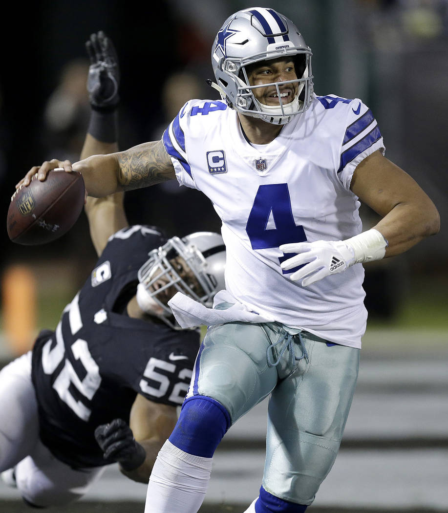 FILE - In this Dec. 17, 2017, file photo, Dallas Cowboys quarterback Dak Prescott (4) passes in front of Oakland Raiders defensive end Khalil Mack (52) during the first half of an NFL football gam ...