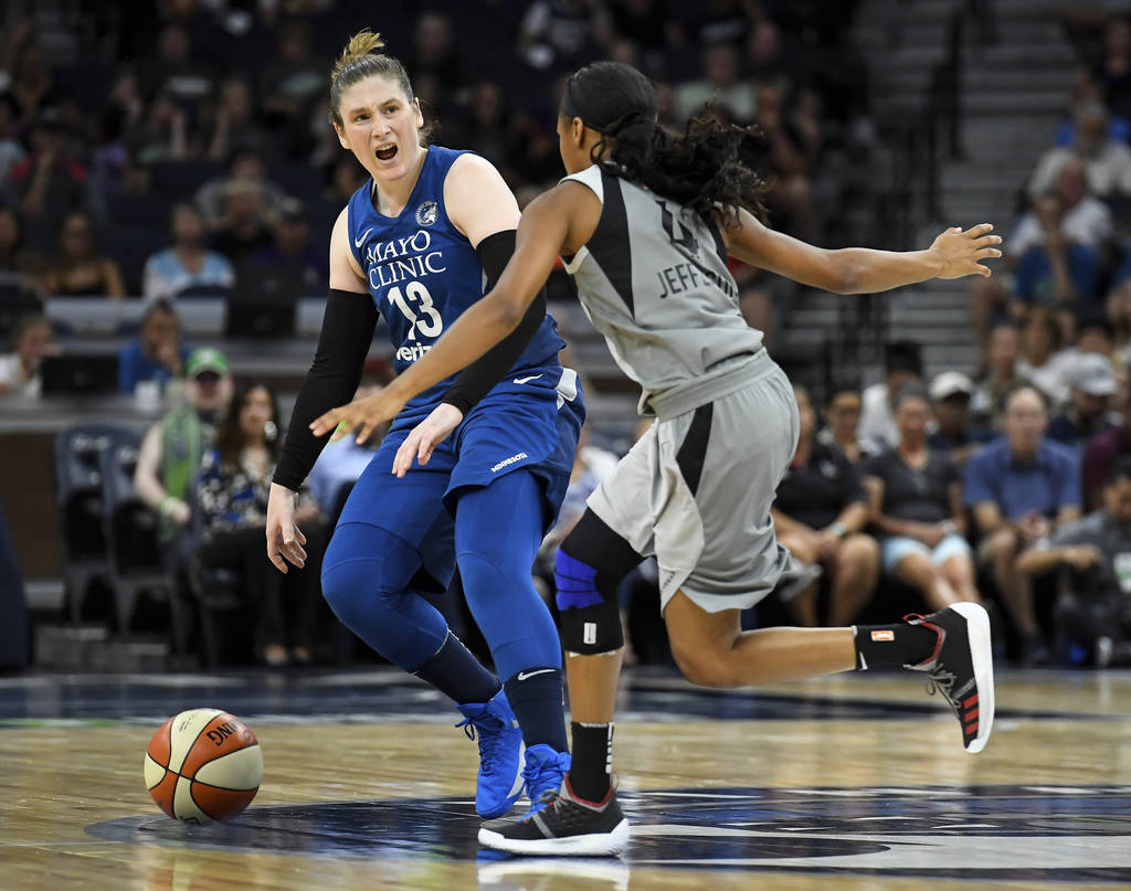 Minnesota Lynx guard Lindsay Whalen directs her teammates while moving the ball down the court under defense by Las Vegas Aces guard Moriah Jefferson (4) during the first half of a WNBA basketball ...