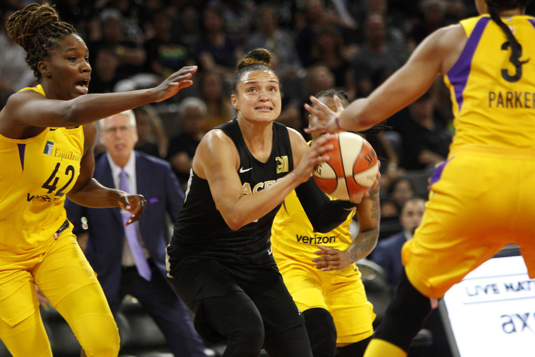 Las Vegas Aces guard Kayla McBride (21) looks to shoot a basket past Los Angeles Sparks center Jantel Lavender (42) and (3) during the second half of a WNBA basketball game at the Mandalay Bay Eve ...