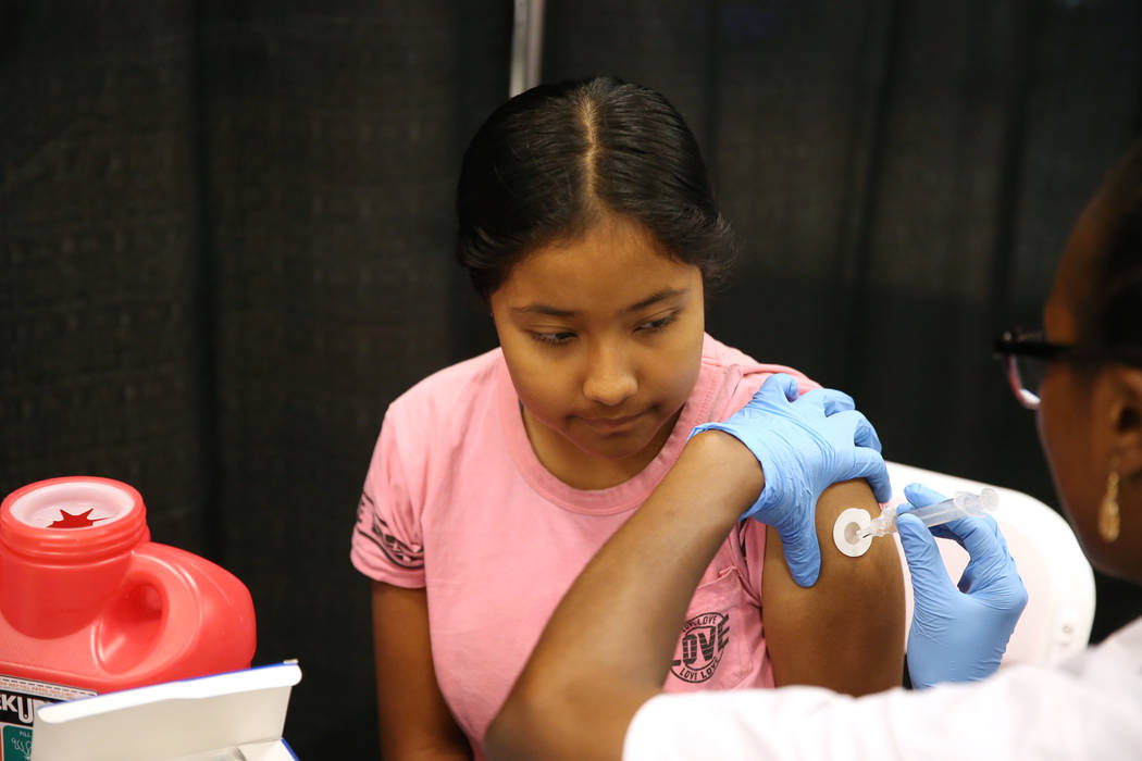 Lupita Rojas, 11, a seventh-grade-student from Las Vegas, receives a vaccine during the annual Cox Back to School Fair at Boulevard Mall in Las Vegas, Saturday, July 28, 2018. Erik Verduzco Las Ve ...