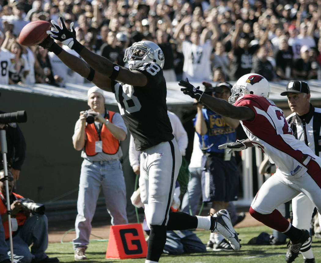 Oakland Raiders wide receiver Randy Moss (18) misses a catch in the end zone in front of Arizona Cardinals Antrel Rolle (21) in the first quarter of their NFL football game, Sunday, Oct. 22, 2006 ...