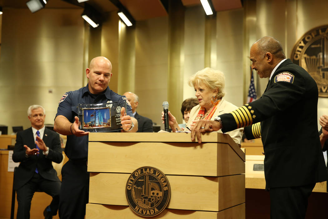 Las Vegas Mayor Carolyn Goodman, center, with Las Vegas Fire and Rescue Chief William McDonald, right, recognize paramedic Matthew Driscoll as the employee of the month, during a city council meet ...
