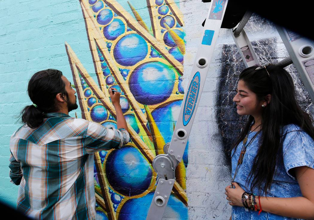 A muralist live painting a wall during First Friday in the Las Vegas Arts District