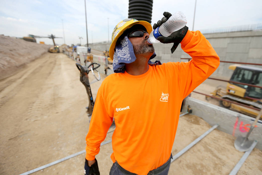 Thomas Farino drinks water while working on a retaining wall for the "Neon Gateway" high-occupancy vehicle exit ramps as part of Nevada Department of Transportation Project Neon on Inter ...