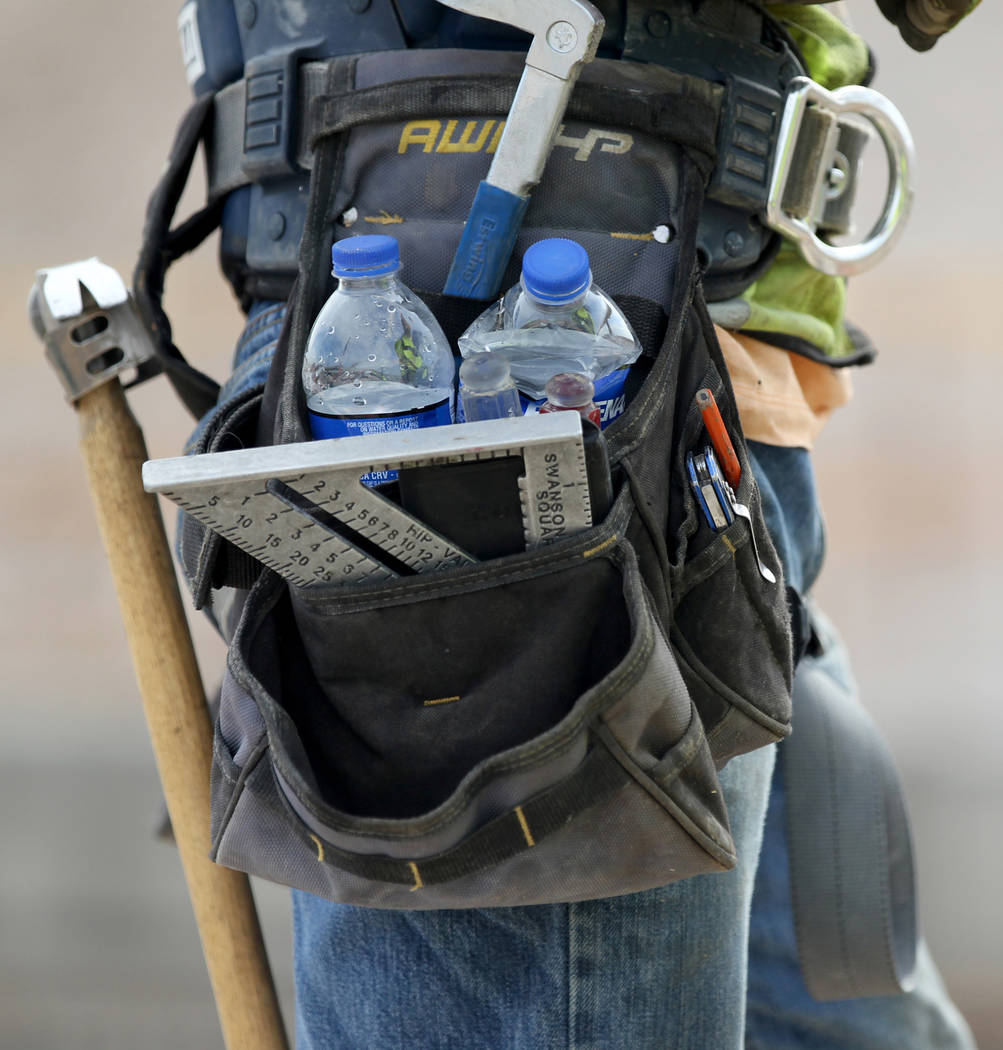 A worker carries bottles of water while working on Nevada Department of Transportation Project Neon on Interstate 15 between the Spaghetti Bowl and Sahara Avenue Thursday, Aug. 2, 2018. K.M. Canno ...