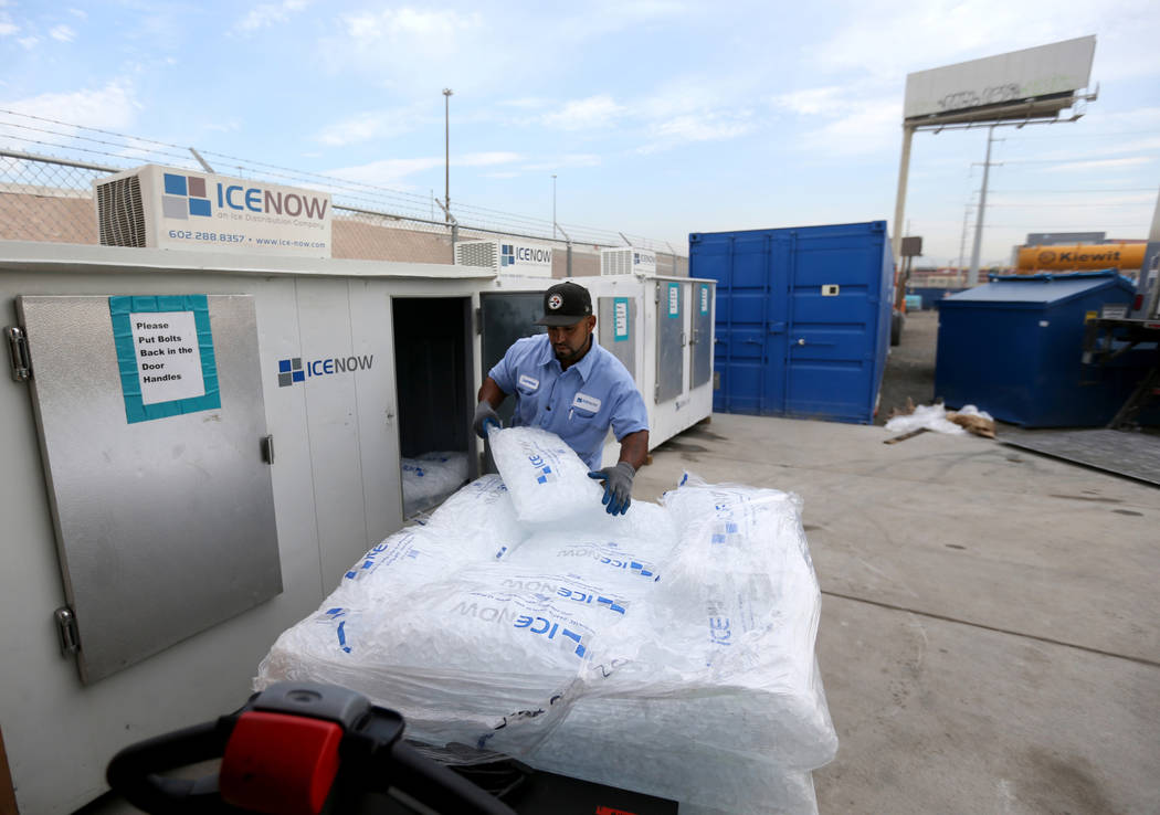 Lorenzo Tapia of Ice Now loads bags of ice into freezers at Nevada Department of Transportation Project Neon Kiewit facility adjacent to Interstate 15 Thursday, Aug. 2, 2018. The ice is used in co ...