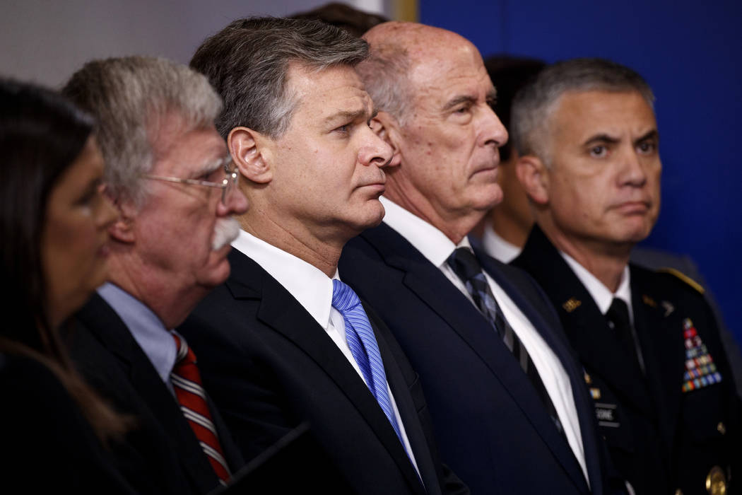 FBI Director Christopher Wray listens during the daily press briefing at the White House, Thursday, Aug. 2, 2018, in Washington. From left also listening are White House press secretary Sarah Huck ...