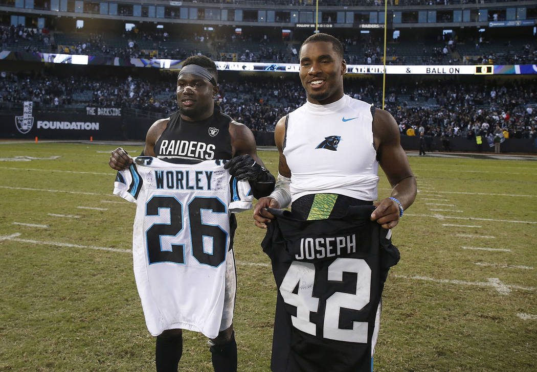 Oakland Raiders safety Karl Joseph, left, and Carolina Panthers cornerback Daryl Worley pose for photos after swapping jerseys after an NFL football game in Oakland, Calif., Sunday, Nov. 27, 2016. ...
