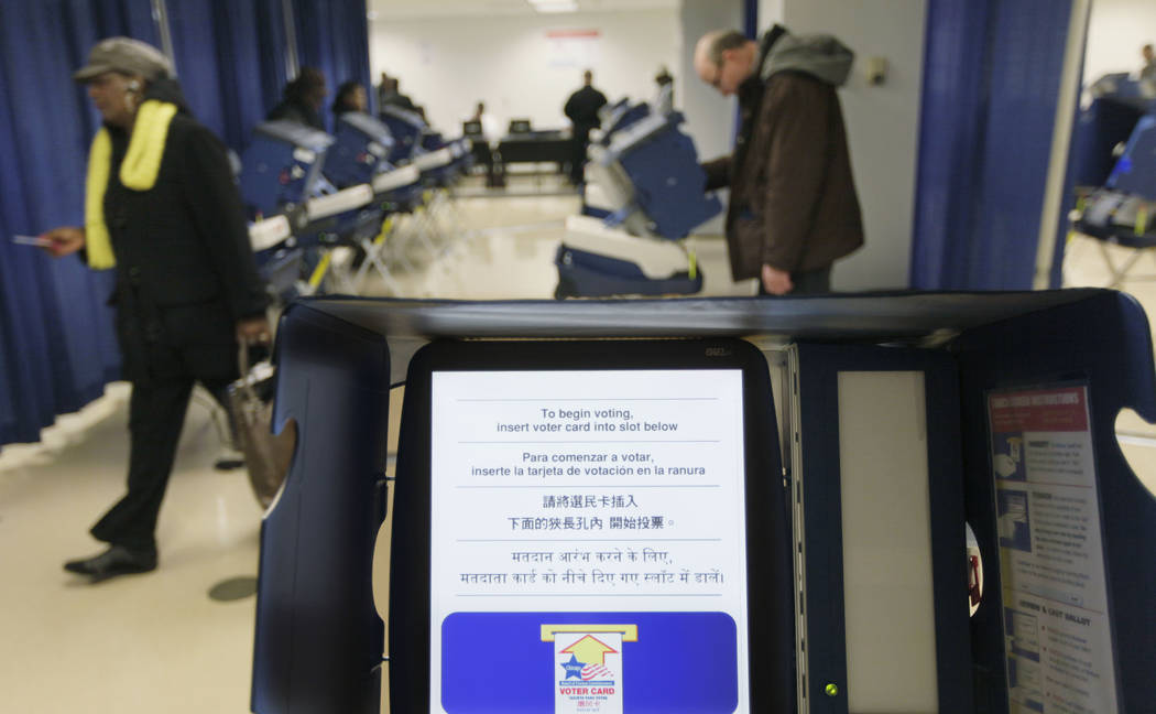 In this Feb. 27, 2012 file photo, voters cast their ballots during early voting at the Board of Elections building, in downtown Chicago. Illinois is set to receive $13.9 million in federal funds a ...