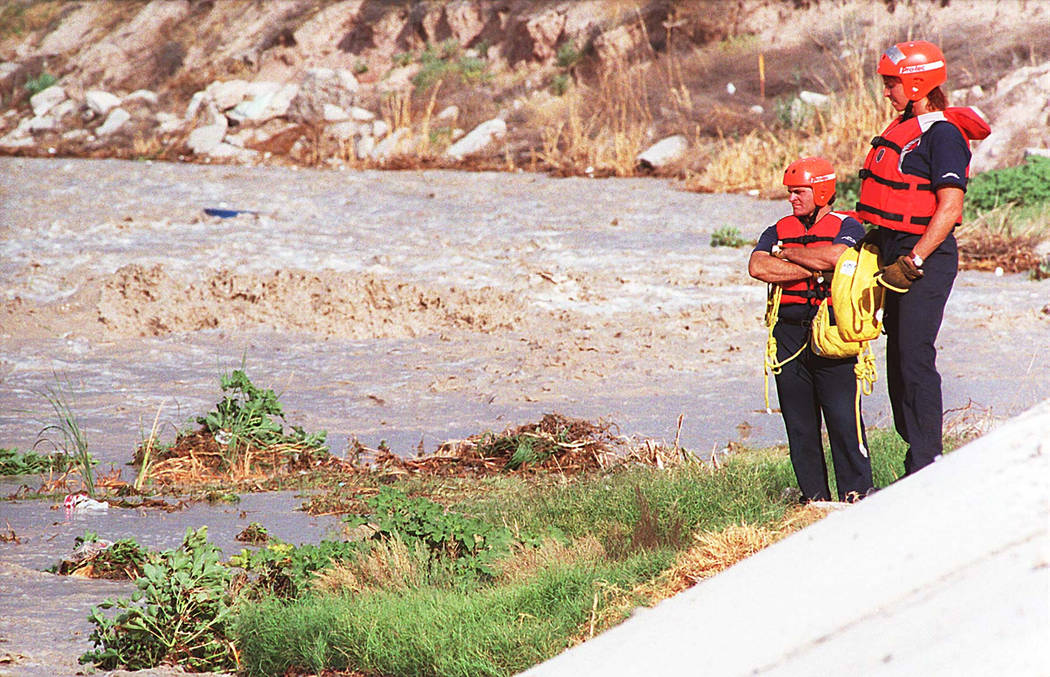 Firefighters Clark Leferve, left, and Sheila Tarr stand by a wash near Eastern Ave in 1995. (Las Vegas Review-Journal File Photo)