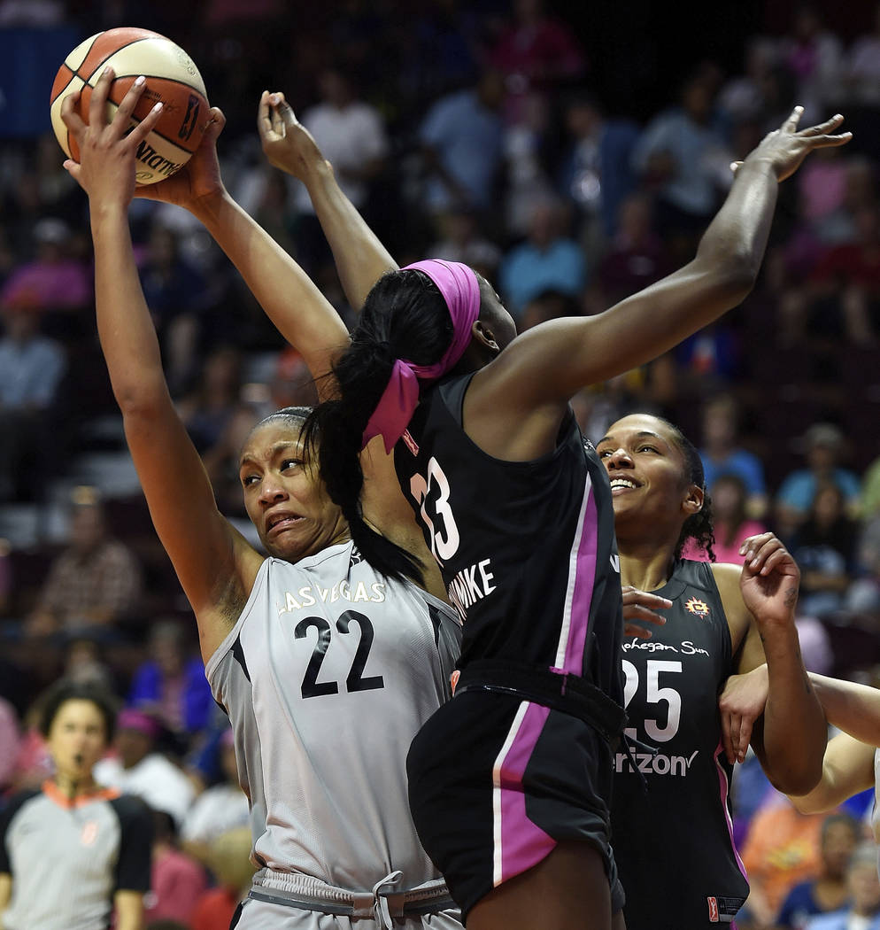 Las Vegas Aces forward A'ja Wilson (22) takes a rebound away from Connecticut Sun forward Chiney Ogwumike (13) and Alyssa Thomas (25) in the second half of WNBA basketball game action Sunday, Aug. ...