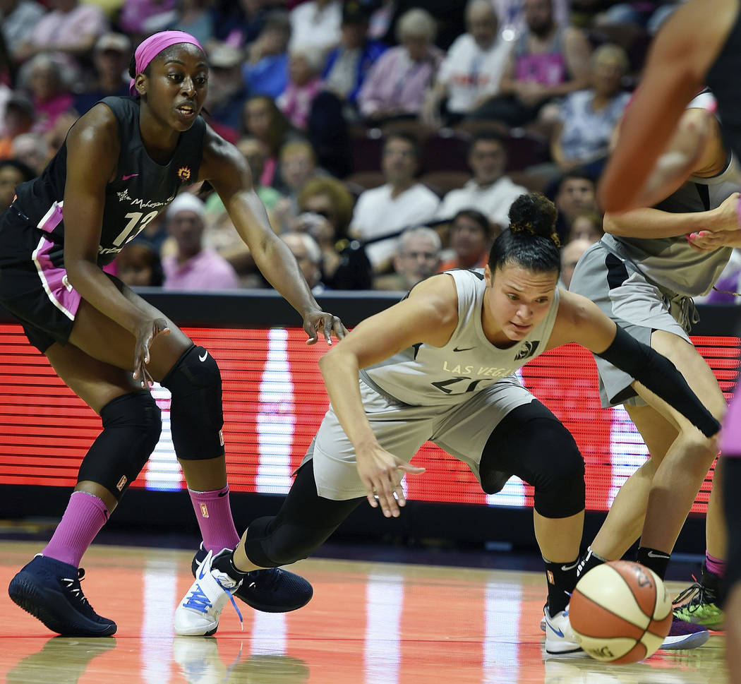 Las Vegas Aces guard Kayla McBride (21) dives after the ball after it was knocked away by Connecticut Sun forward Chiney Ogwumike (13) in the first half of WNBA basketball game action Sunday, Aug. ...
