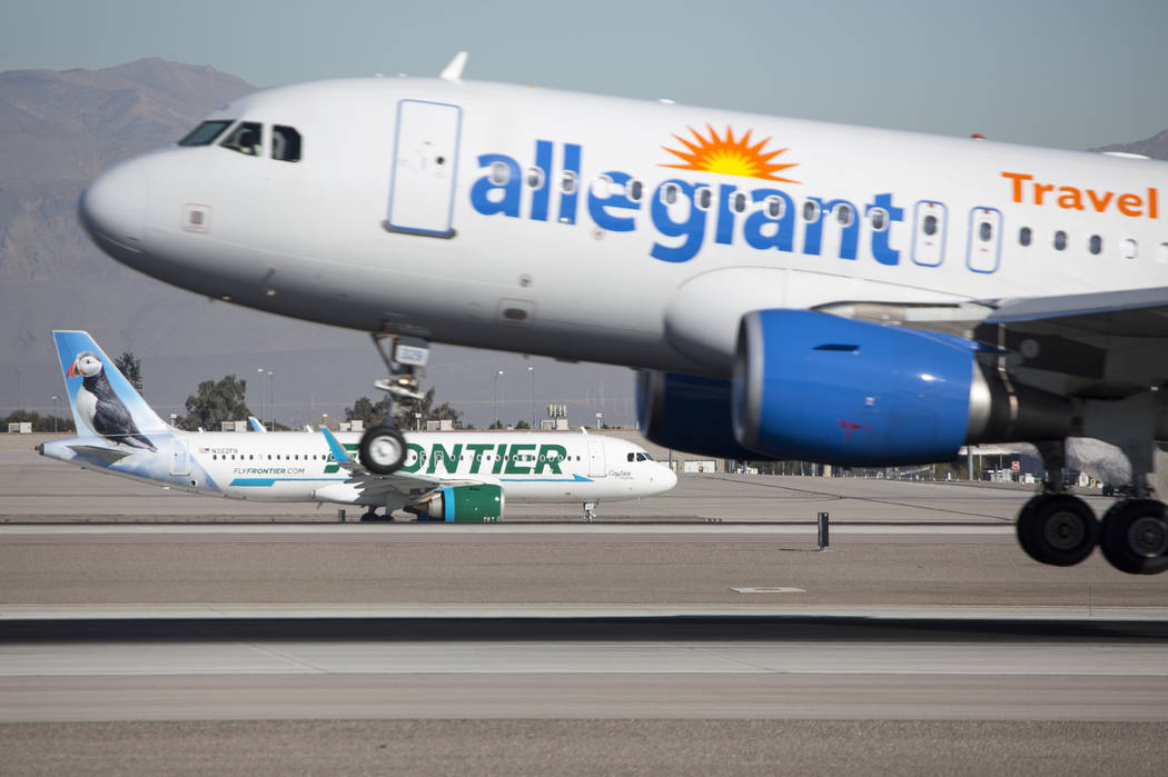 An Allegiant Air flight descends onto the runway as a Frontier Airlines aircraft taxis the tarmac at McCarran International Airport in Las Vegas on Monday, Jan. 22, 2018. Richard Brian Las Vegas R ...