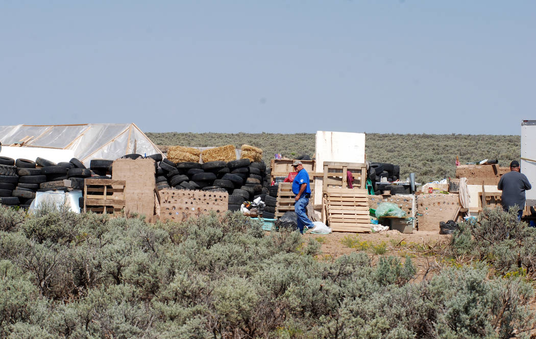 Taos County Solid Waste Department Director Edward Martinez, center, surveys property conditions at a disheveled living compound at Amalia, N.M., on Tuesday, Aug. 7, 2018. A New Mexico sheriff sai ...