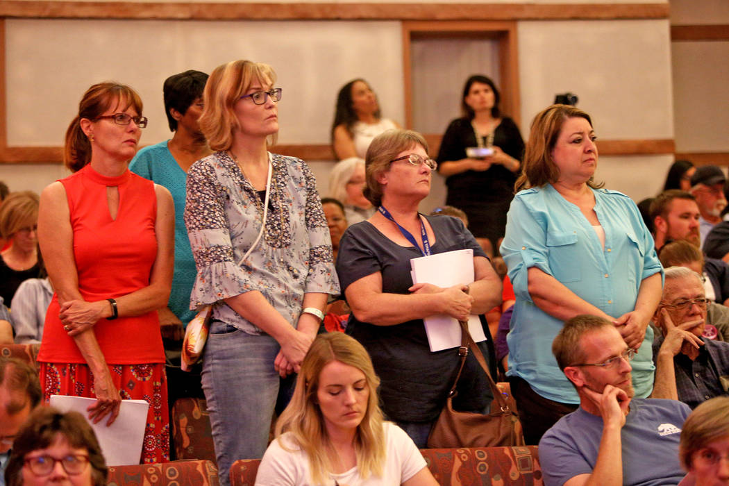 Support staff stand while listening to a speaker at a Clark County School District board meeting at the Clark County Government Center in Las Vegas, Thursday, Aug. 9, 2018. The district's roughly ...