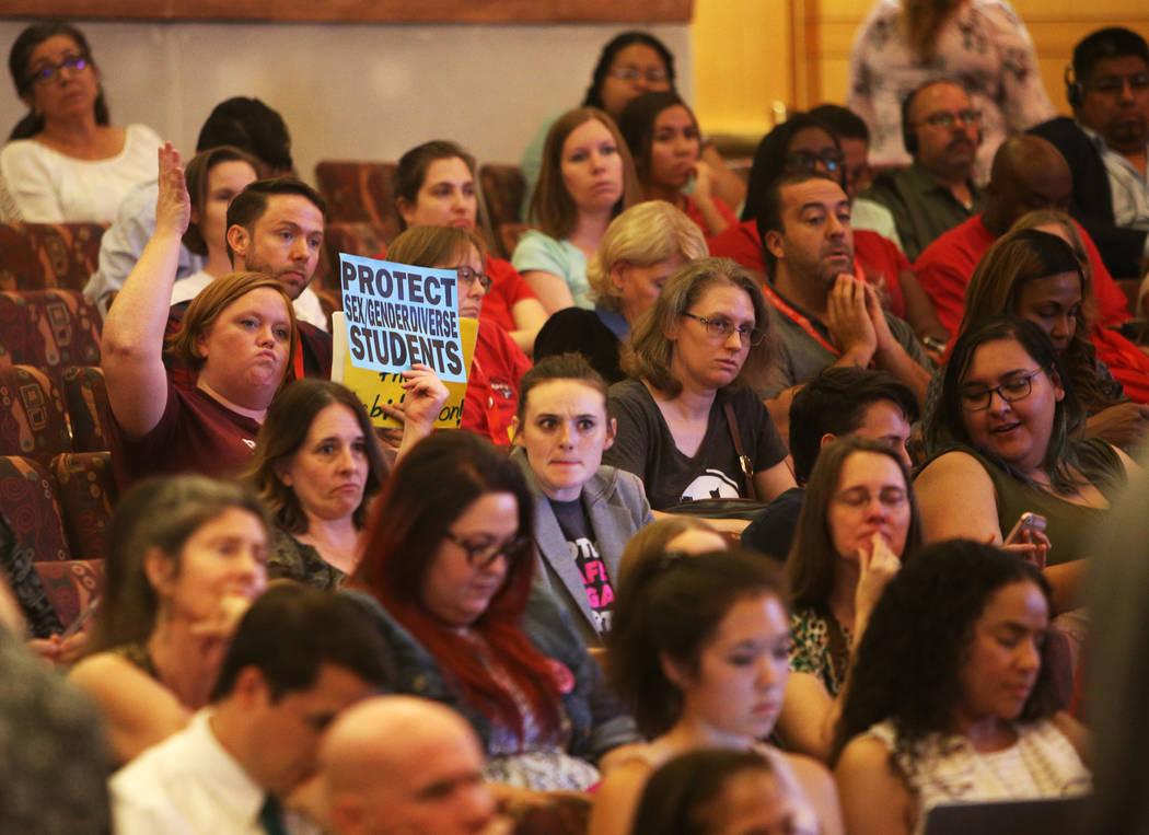 A person holds a sign saying "protect sex gender diverse students" at a Clark County ...