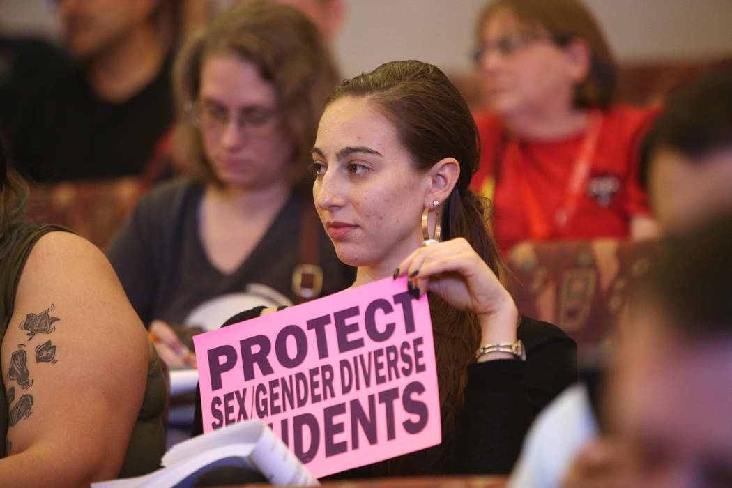 Caity Gwin holds a sign saying "protect sex gender diverse students" at a Clark County School District board meeting at the Clark County Government Center in Las Vegas, Thursday, Aug. 9, 2018. The ...